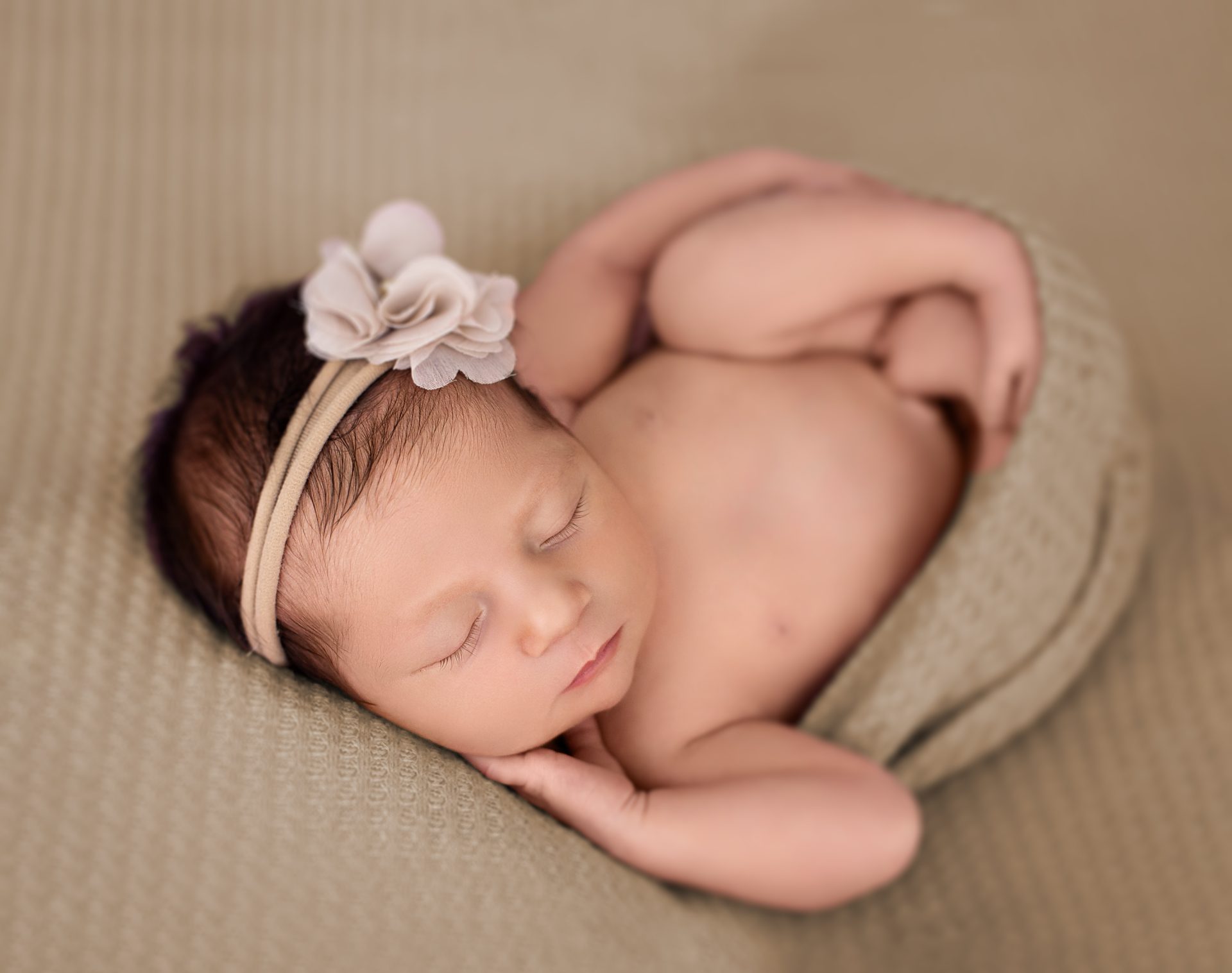 Recién nacido en cesta con mantas suaves y luz natural