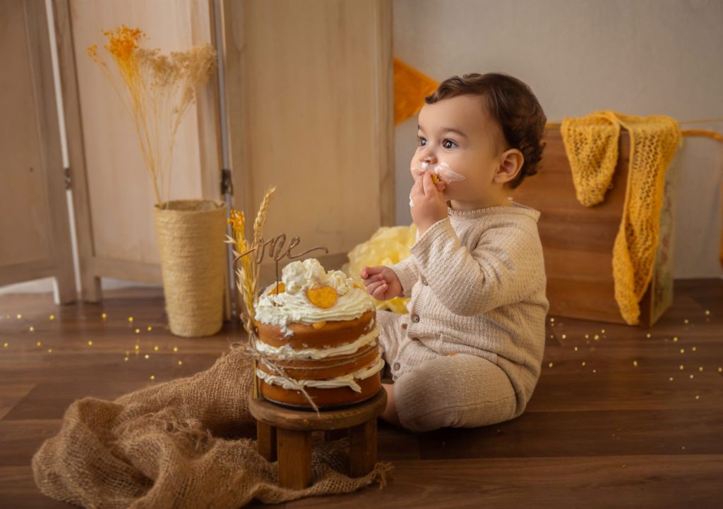 Retrato de primer cumpleaños en tonos amarillos, sesión smash cake de estilo atemporal