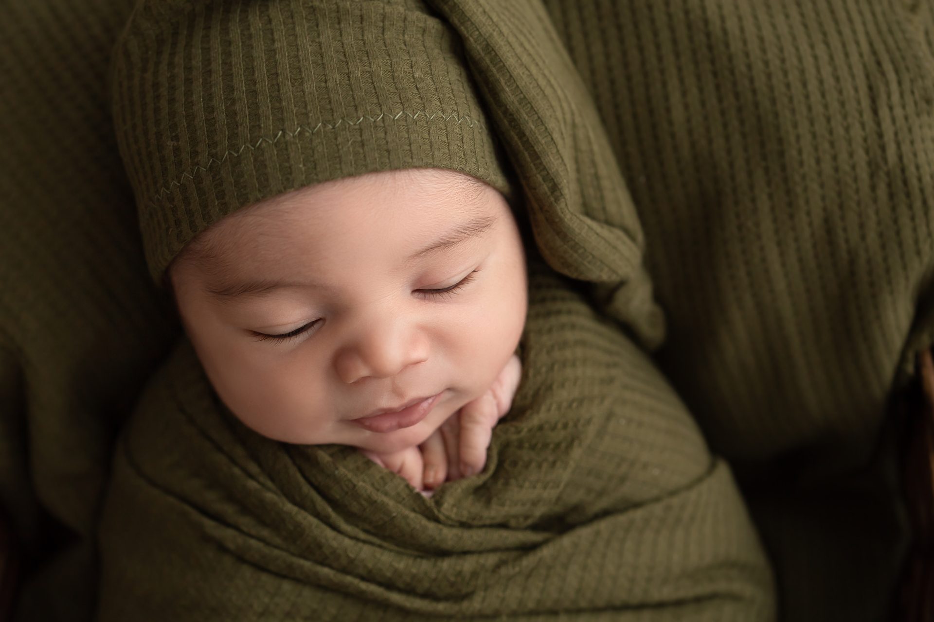 Recién nacido envuelto en tela rústica en sesión artística en Bizkaia