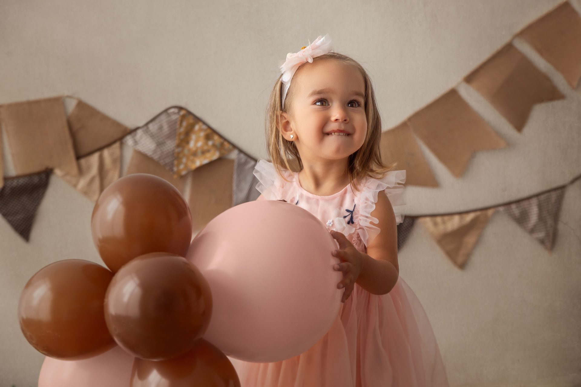 Niña con corona de cumpleaños en sesión Cake Smash en estudio