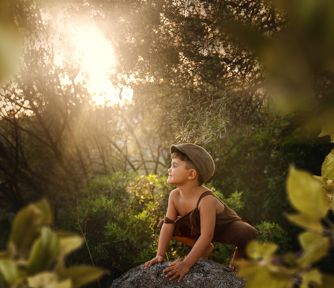 Escena infantil en Bilbao, niño con gorra vintage jugando entre la hierba