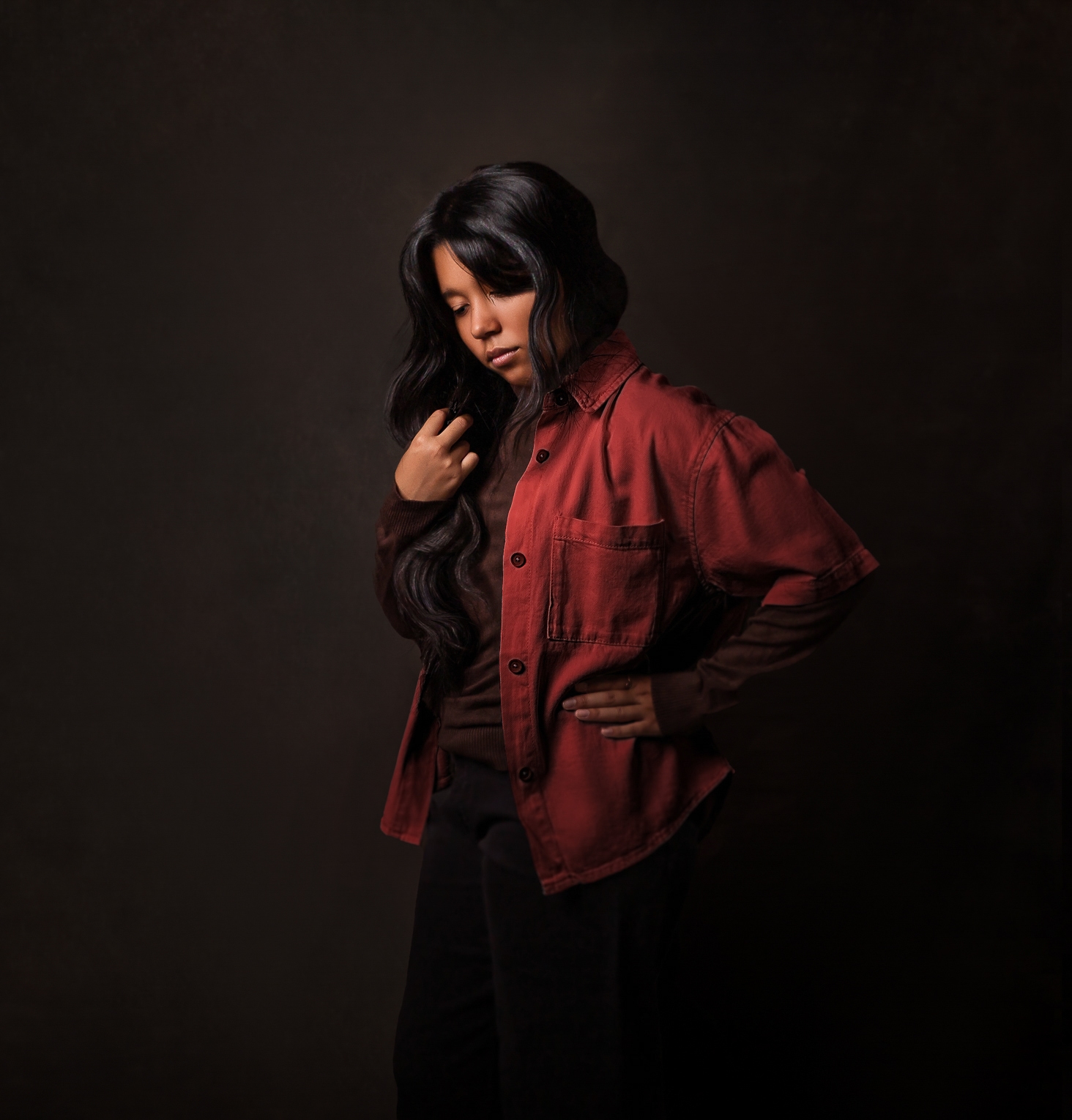 Chica latina disfrutando de su sesión de retrato, con pose relajada