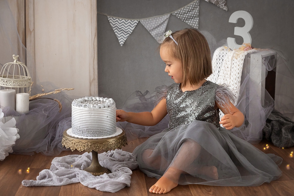 Niño de 3 años en sesión smash cake con temática gris y blanca