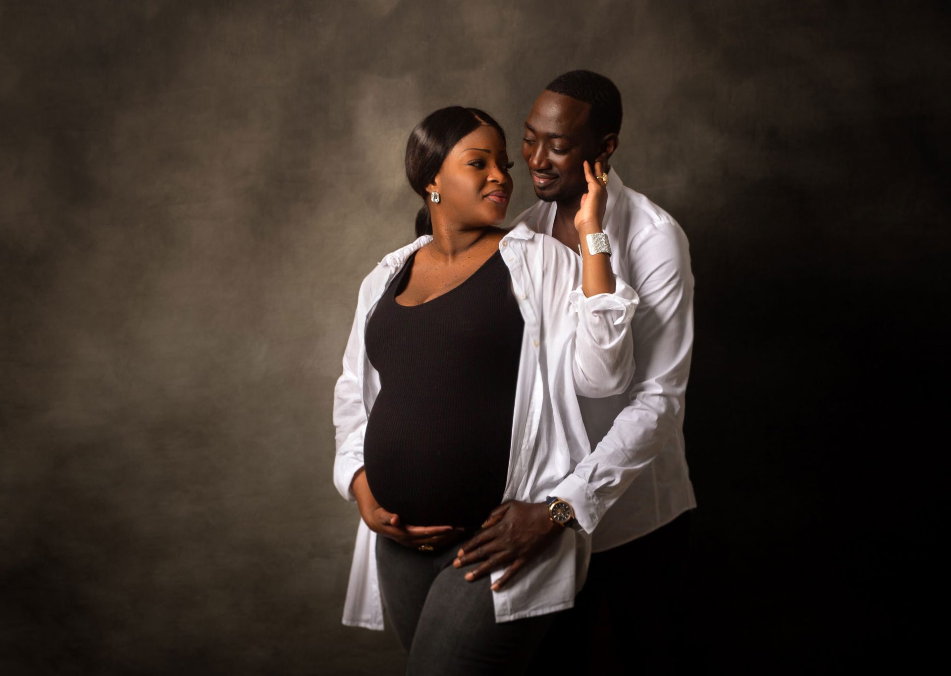 Sesión de embarazo en pareja con futuro papá abrazando a mamá